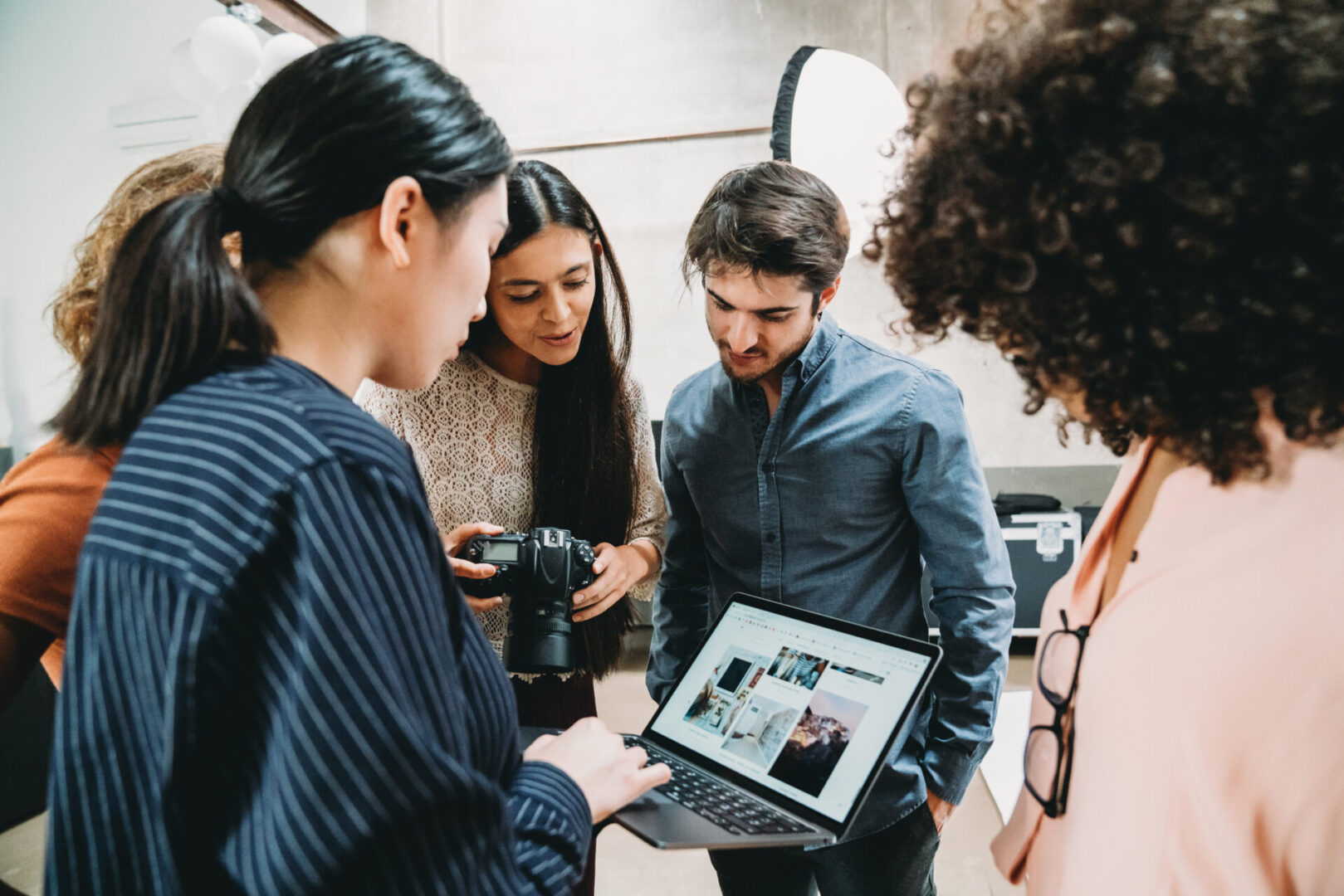 Group reviewing photos on a laptop screen.