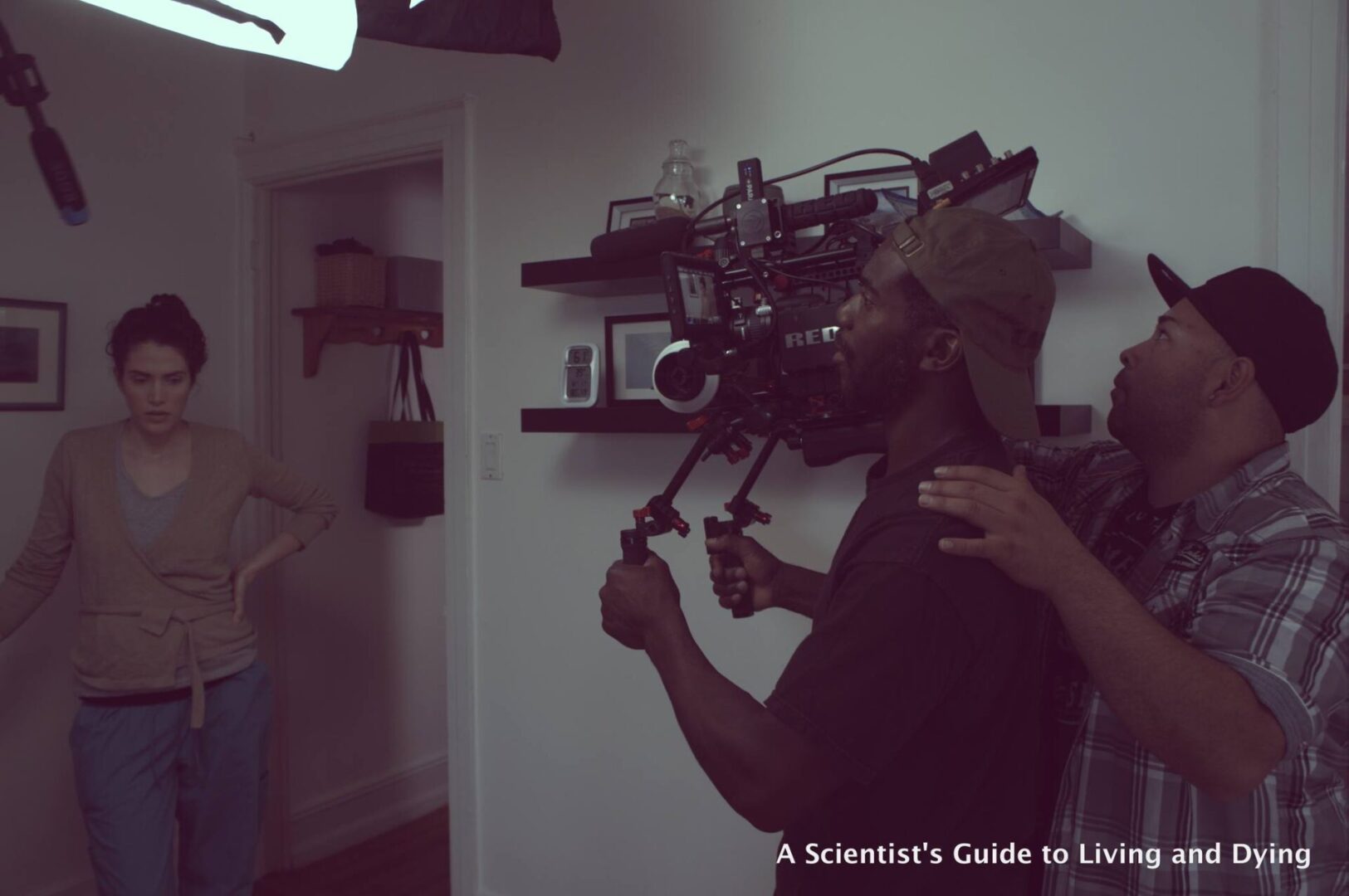 A person filming indoors with professional camera equipment.