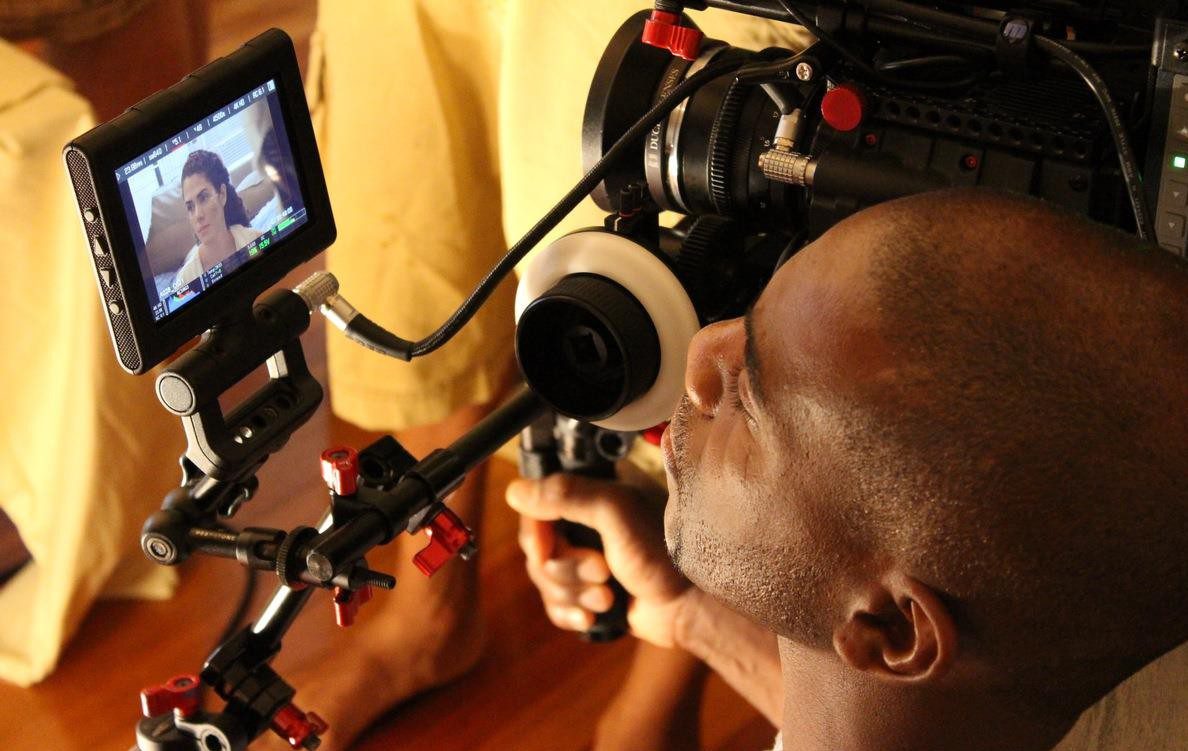 A man operating a professional camera rig with headphones.