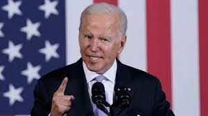 A man speaking passionately at a podium with an American flag backdrop.