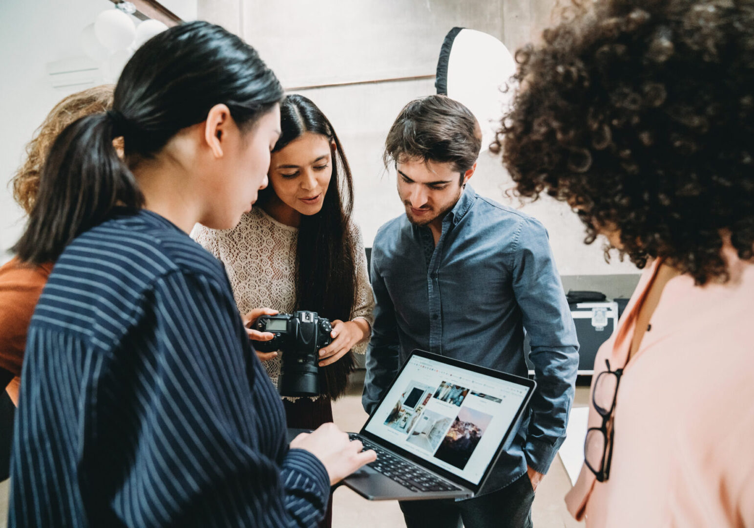 Group reviewing photos on a laptop screen.