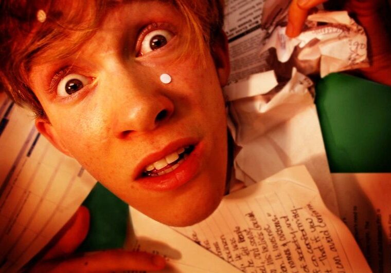 A surprised young person with wide eyes and a letter in front of them.