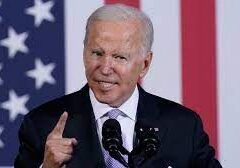 A man speaking passionately at a podium with an American flag backdrop.
