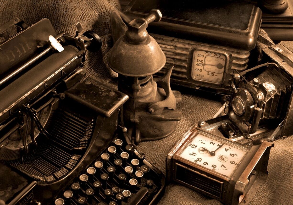Vintage office items including a typewriter, lantern, radio, and clock.
